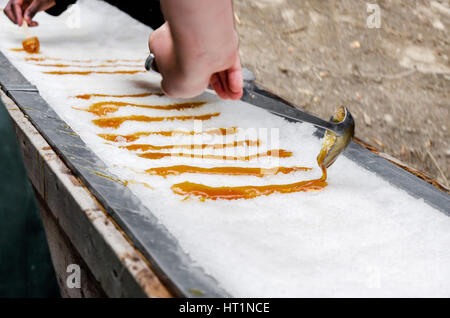 Maple taffy on snow during sugar shack period. In Quebec, Canada. Stock Photo