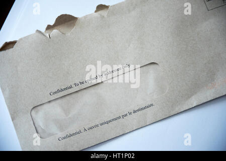 A grey envelope with 'Confidential To Be Opened By Addressee only' written in English and French on the front. Stock Photo