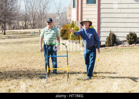 Two senior Caucasian men play ladder golf, or Ladder Toss game in the yard. USA. Stock Photo