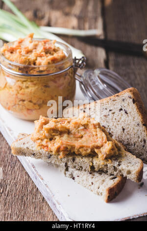 Homemade bean paste, Sandwiches with vegan pate on whole wheat bread. Dip of white beans in glass jar on rustic wooden table. Useful and healthy veget Stock Photo