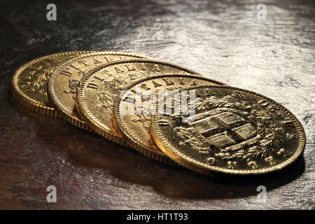 Italian Victor Emmanuel II gold coins on rustic wooden background Stock Photo