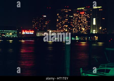 At night, a neon sign is visible on the headquarters building of the Miami Herald newspaper at One Herald Plaza, with the Miami Marriott hotel also visible, Miami, Florida, 1987. Stock Photo