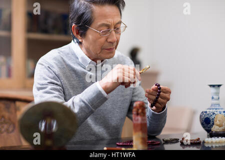 Senior man admiring antiques Stock Photo