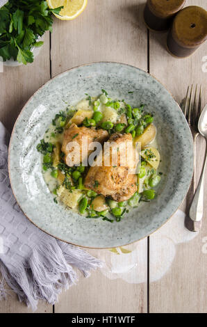 Roast chicken thighs with broad beans and herbs Stock Photo