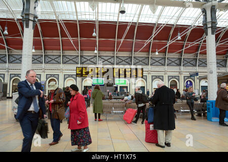 Passengers arriving and departing from Paddington Railway Station in London England - the station has lots of departure and arrival boards for info Stock Photo