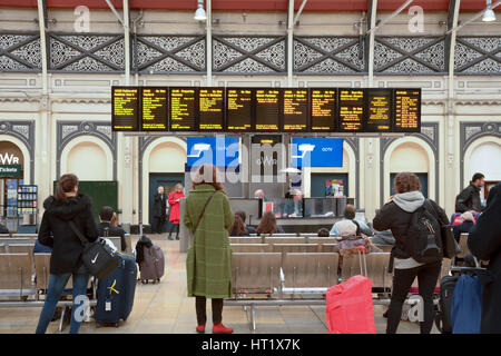 Passengers arriving and departing from Paddington Railway Station in London England - the station has lots of departure and arrival boards for info Stock Photo