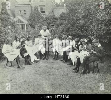 Pupils in the garden doing needlework, Birley House Open Air School, Forest Hill, London, 1908. Artist: Unknown. Stock Photo