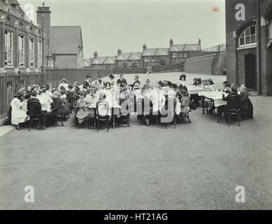 Children eating dinner at tables in the playground, Shrewsbury House Open Air School, London, 1908. Artist: Unknown. Stock Photo