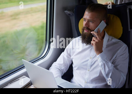 Young businessman talking by mobile phone in the train Stock Photo