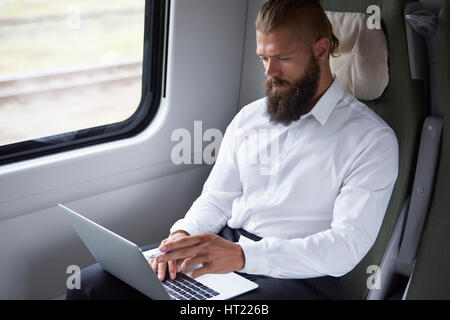 Modern businessman working in the train Stock Photo