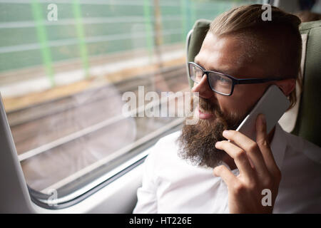 Businessman with mobile phone in the train Stock Photo