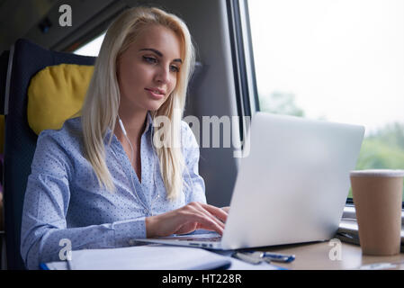Blonde businesswoman working in the train Stock Photo