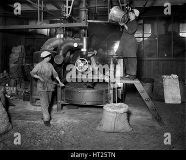 Two women filling Sirocco roaster with coffee beans, J Lyons and Co, London, July 1918.  Artist: Adolph Augustus Boucher. Stock Photo