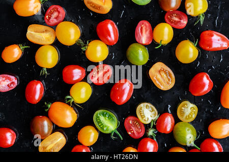 Multi-colored tomatoes on black background Stock Photo
