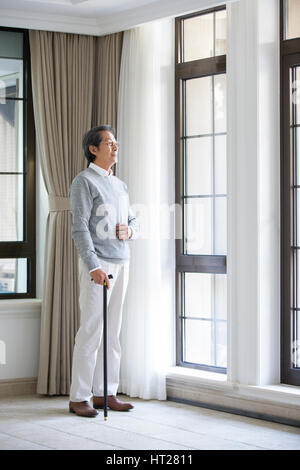 Senior man looking out window Stock Photo