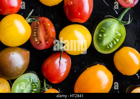 Multi-colored tomatoes on black background Stock Photo