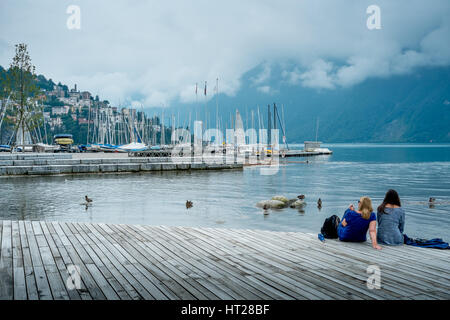 Two girls enjoy the tranquil waters of Lake Lugano, Switzerland. Stock Photo