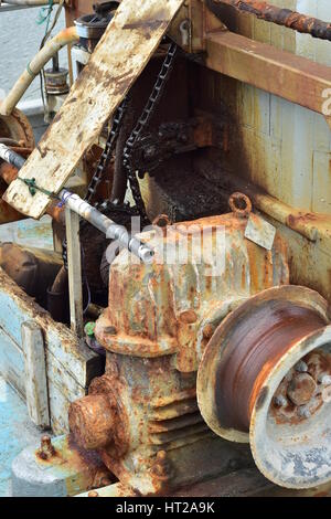 Rusty commercial fishing equipment including winch on board of fishing vessel. Stock Photo