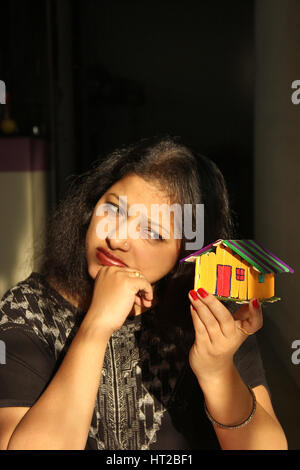 Young woman dreaming or planning to buy house Stock Photo