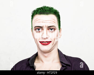 guy with crazy joker face, green hair and idiotic smike. carnaval costume. Stock Photo