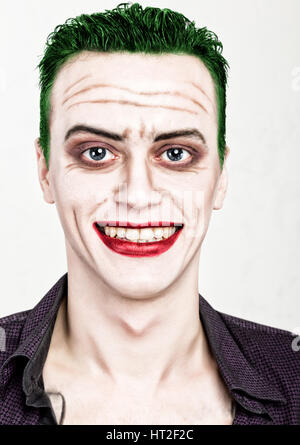 guy with crazy joker face, green hair and idiotic smike. carnaval costume. Stock Photo