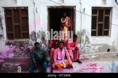 Mathura, Uttar Pradesh, India. 7th Mar, 2017.  Indian Hindu devotee sit in front of their house during the annual Lathmar Holi festival in Nandgaon village, Mathura, India, 07 March 2017. Holi is the Hindu spring festival of colors. In Barsana, people celebrate a variation of holi, called 'Lathmar' Holi, which means 'beating with sticks'. During the Lathmar Holi festival, the women of Nandgaon, the hometown of Hindu God Krishna, beat the men from Barsana, the birthplace of Radha, with wooden sticks in response to their efforts to throw color on them. Credit: ZUMA Press, Inc./Alamy Live News Stock Photo