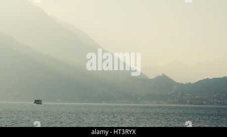 Ferry swim in the lake, contrasting the evening lighting. Lake Como, Italy. Stock Photo