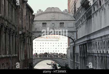 Venezia, VE, Italy - July 14, 2015: bridge of sighs with torustis and a big cruise ship behind   while sailing towards the port along the Giudecca can Stock Photo