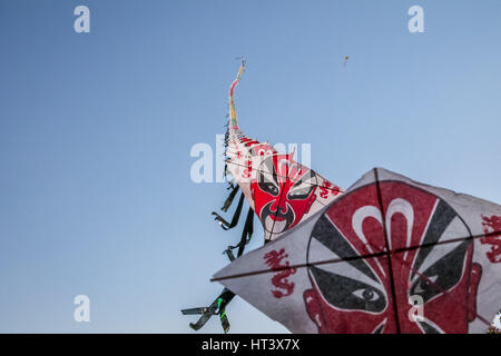 Row of chinese paper kites flying on clear blue sky Stock Photo
