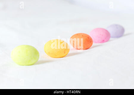 Spring colorful easter eggs sitting in a white sheet forming a diagonal line and white some space between them Stock Photo