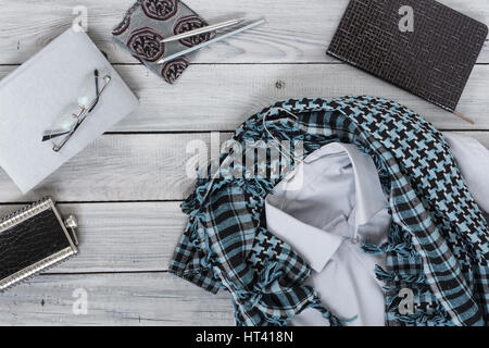 Fragment of a men's shirt with a keffiyeh on a hanger, diary, water bottle on a wooden painted surface. The pastel colors Stock Photo