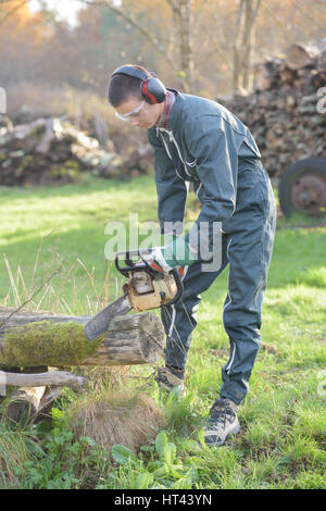 Man using chainsaw Stock Photo