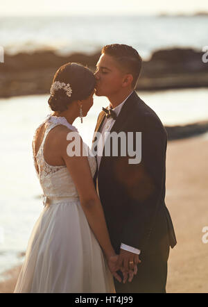 Kissing married wedding couple on sunny beach sunset. Romantic evening for young couple Stock Photo