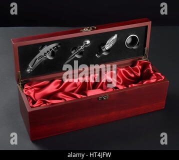 Set of a vine opener in a wooden case with bottle of red vine. Isolated on white. Stock Photo