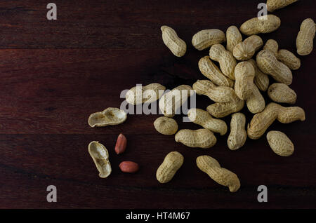 Peanuts in shells on dark wooden board Stock Photo