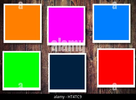 Vintage colorful picture frames on the brown wooden background. Stock Photo