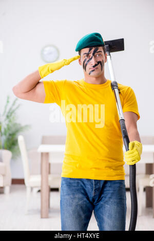 Funny man in military style cleaning the house Stock Photo