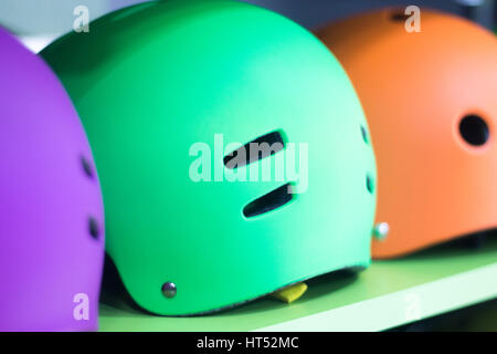 Inline and quad roller skates helmets head protection in retail skate shop display on sale. Stock Photo