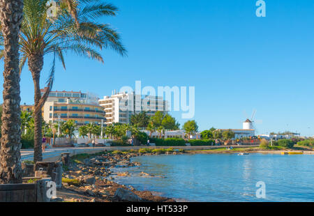 Ibiza sunshine on the bay in St Antoni de Portmany,  Ibiza,  Balearic Islands, Spain.  Hotels along the shoreline offer places to stay for holidays. Stock Photo