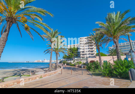 Ibiza sunshine on the bay in St Antoni de Portmany,  Ibiza,  Balearic Islands, Spain.  Hotels along the shoreline offer places to stay for holidays. Stock Photo