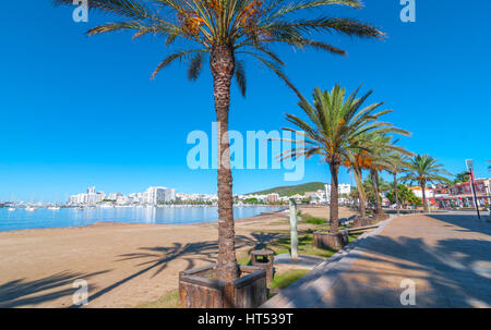 Ibiza sunshine on waterfront in Sant Antoni de Portmany,  Take a walk along main boardwalk, now a stone concourse, beside the beach in warm Ibiza. Stock Photo