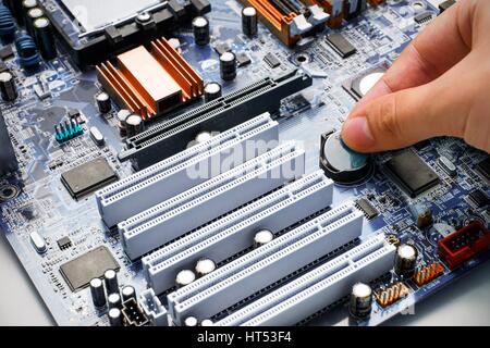 Hand install battery to PC motherboard Stock Photo