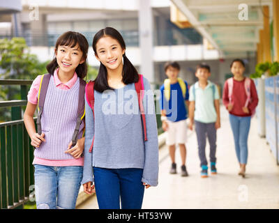 asian elementary school girls walking in classroom building. Stock Photo