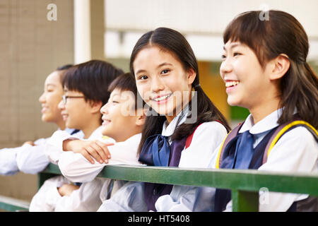 group of asian elementary school children with one schoolgirl looking at camera smiling. Stock Photo