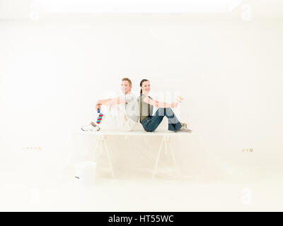 young couple resting after painting their home-office; banner concept image Stock Photo