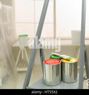 colourful cans of paint on a stepladder window in background ; home improvement concept Stock Photo