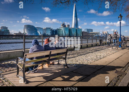 People enjoy the sunshine on the pathway outside the Tower of London on a cold but bright day in the capital city of London. Stock Photo