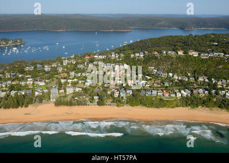 AERIAL VIEW. Residential neighborhood facing the Pacific Ocean with the Pittwater in the distance. Whale Beach, Sydney, New South Wales, Australia. Stock Photo