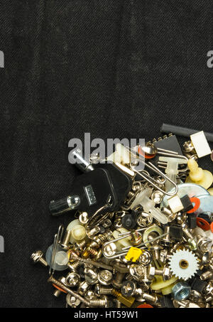 techno backgrounds - various bolts, screws, washers, nuts and other computer small fasteners on black fabric Stock Photo