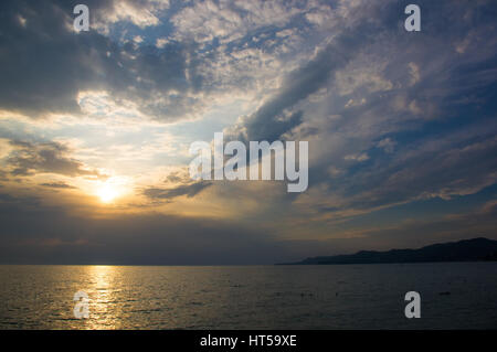 solar path on the sea on a Sunset and yellow sky with clouds Stock Photo